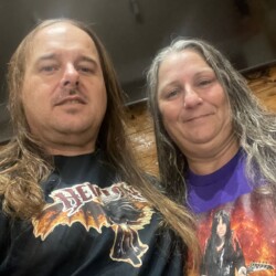 James & Theresa, observed in their natural habitat: spreading the Hellion agenda with style. James and Theresa posing together wearing Hellion merchandise.