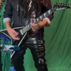 The mastermind himself—no intro needed, just volume. He’s not wearing the merch. He is the merch. Terry Blazer, Hellion’s lead guitarist and creative mastermind, posing for a portrait.